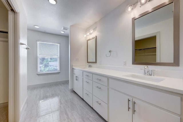 2105 Tiger Trl Unit 302, Round Rock, TX 78665 - bathroom with double vanity, a walk in closet, and baseboards