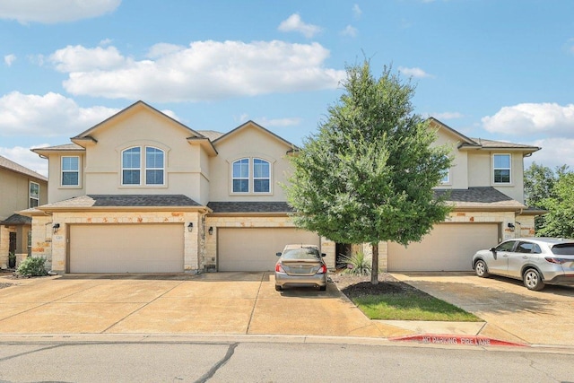 13400 Briarwick Dr Unit 1202, Austin, TX 78729 - view of front of home featuring an attached garage, driveway, stucco siding, and stone siding