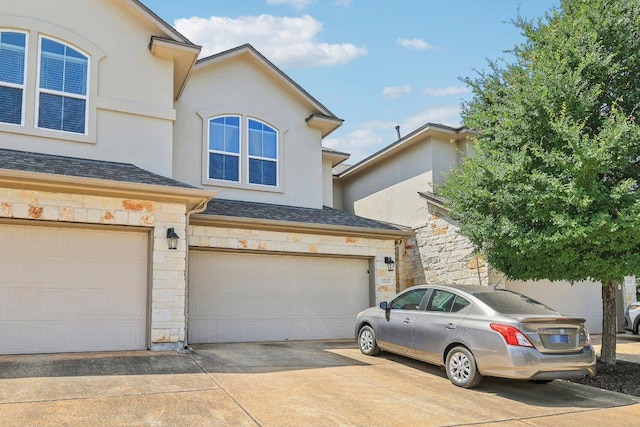 13400 Briarwick Dr Unit 1202, Austin, TX 78729 - view of front of property with a garage, stone siding, stucco siding, and driveway