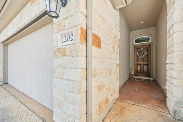 13400 Briarwick Dr Unit 1202, Austin, TX 78729 - doorway to property featuring stone siding and a garage