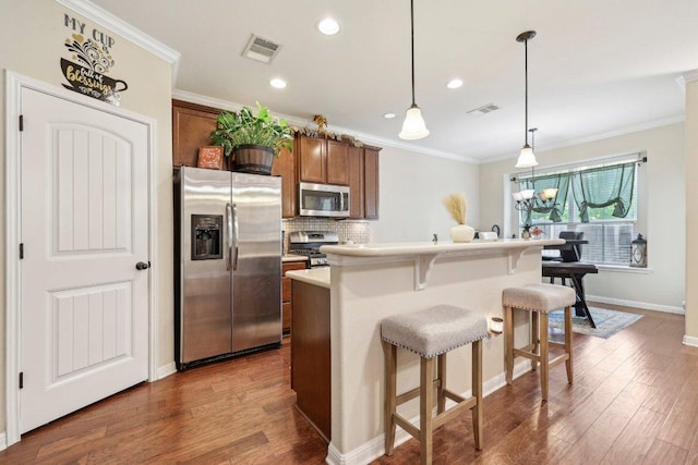13400 Briarwick Dr Unit 1202, Austin, TX 78729 - kitchen with appliances with stainless steel finishes, a breakfast bar, backsplash, dark wood-style floors, and ornamental molding