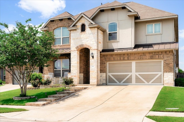 211 Joseph Dr, Buda, TX 78610 - french country style house featuring a standing seam roof, a garage, stone siding, concrete driveway, and roof with shingles