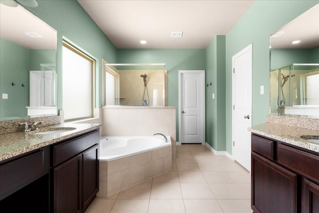 211 Joseph Dr, Buda, TX 78610 - bathroom featuring a shower stall, two vanities, tile patterned flooring, a bath, and baseboards