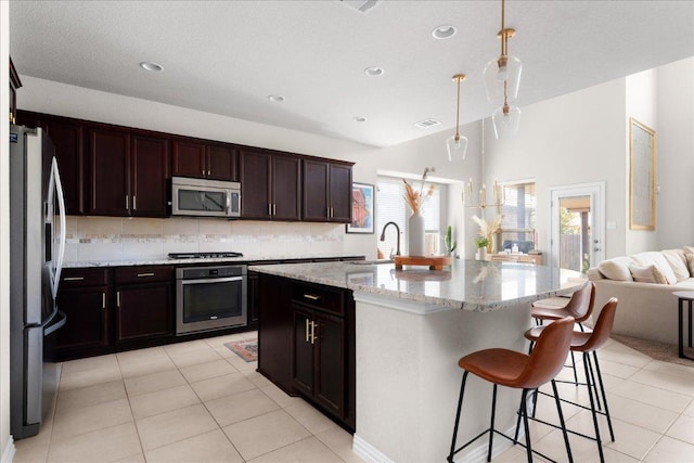 211 Joseph Dr, Buda, TX 78610 - kitchen with appliances with stainless steel finishes, backsplash, open floor plan, light tile patterned floors, and pendant lighting