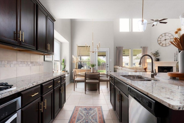 211 Joseph Dr, Buda, TX 78610 - kitchen with a sink, appliances with stainless steel finishes, open floor plan, backsplash, and a towering ceiling