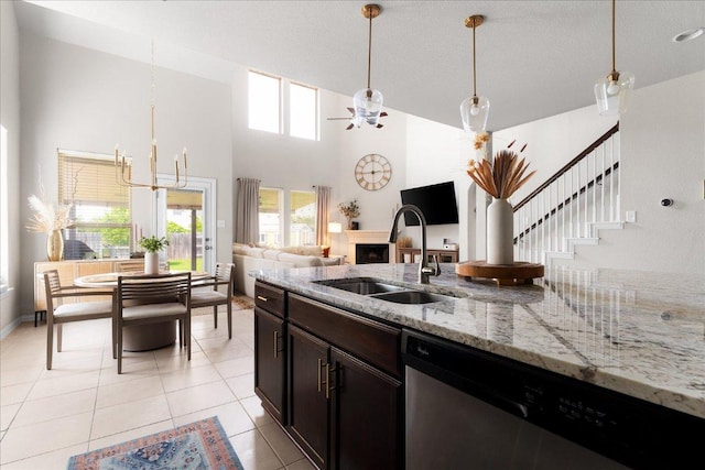 211 Joseph Dr, Buda, TX 78610 - kitchen featuring dishwasher, a sink, decorative light fixtures, light tile patterned floors, and a high ceiling