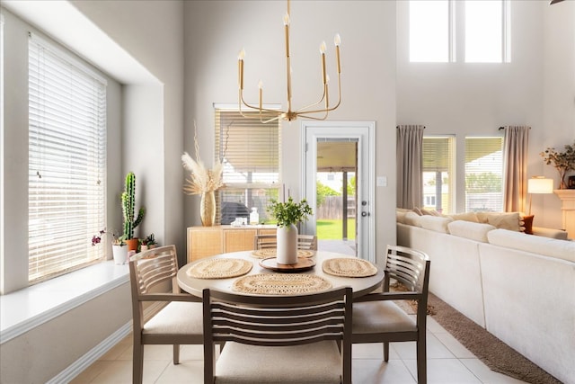 211 Joseph Dr, Buda, TX 78610 - dining area with a chandelier, a towering ceiling, healthy amount of natural light, light tile patterned floors, and baseboards