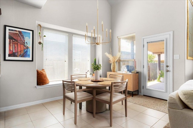 211 Joseph Dr, Buda, TX 78610 - dining space featuring a chandelier, a high ceiling, baseboards, and light tile patterned flooring