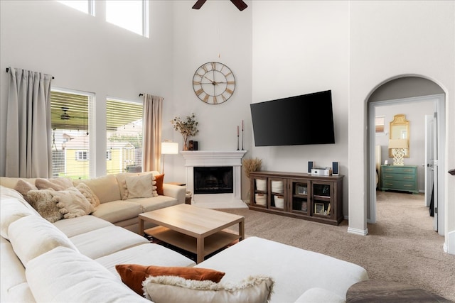 211 Joseph Dr, Buda, TX 78610 - living room with a towering ceiling, light carpet, a ceiling fan, and a fireplace with raised hearth