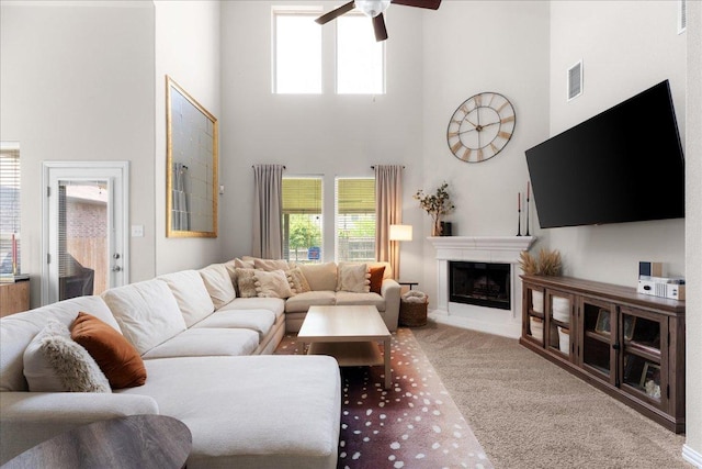 211 Joseph Dr, Buda, TX 78610 - living room featuring a towering ceiling, carpet floors, ceiling fan, and a fireplace