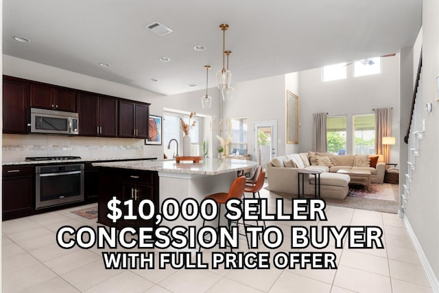211 Joseph Dr, Buda, TX 78610 - kitchen with appliances with stainless steel finishes, a kitchen bar, light tile patterned floors, backsplash, and a sink