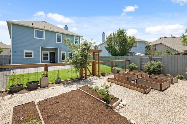 1121 Boxwood Loop, Georgetown, TX 78628 - back of property with a vegetable garden, a fenced backyard, and a gate