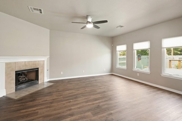 1121 Boxwood Loop, Georgetown, TX 78628 - unfurnished living room with a ceiling fan, dark wood-type flooring, a tile fireplace, and baseboards