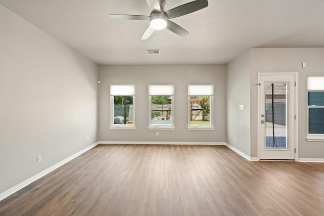 1121 Boxwood Loop, Georgetown, TX 78628 - unfurnished room featuring wood finished floors, healthy amount of natural light, ceiling fan, and baseboards