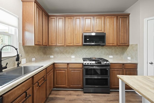 1121 Boxwood Loop, Georgetown, TX 78628 - kitchen with stainless steel appliances, a sink, light countertops, and dark wood finished floors
