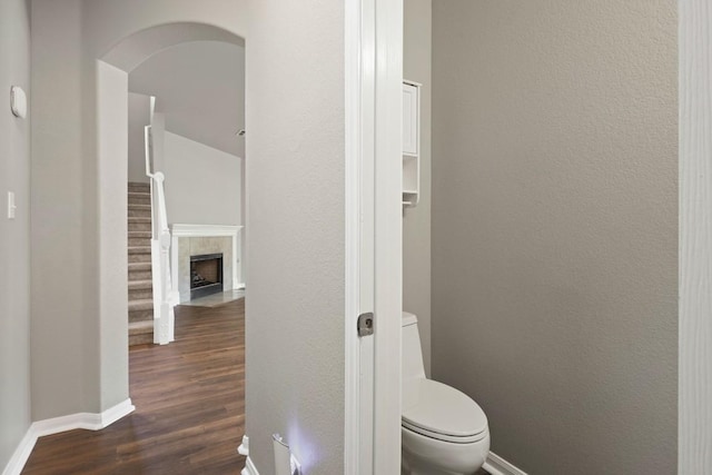 1121 Boxwood Loop, Georgetown, TX 78628 - bathroom featuring baseboards, wood finished floors, toilet, and a fireplace