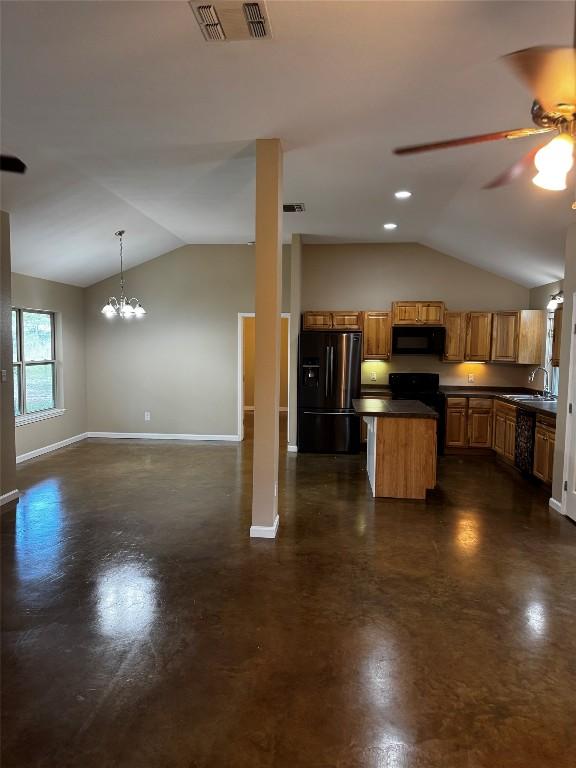106 Shetland Ln, Bastrop, TX 78602 - kitchen with refrigerator with ice dispenser, black microwave, lofted ceiling, baseboards, and dark countertops