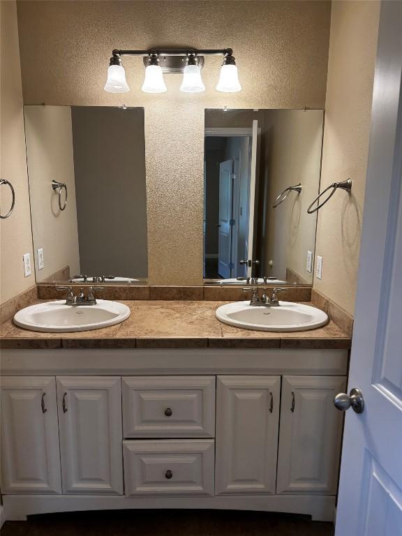 106 Shetland Ln, Bastrop, TX 78602 - bathroom featuring double vanity and a textured wall
