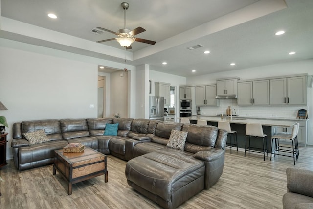 19500 Chayton Cir, Pflugerville, TX 78660 - living area with light wood-style floors, recessed lighting, ceiling fan, and a tray ceiling