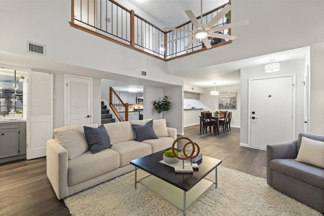 8115 Raintree Pl, Austin, TX 78759 - living room featuring a towering ceiling, stairs, dark wood-type flooring, and baseboards
