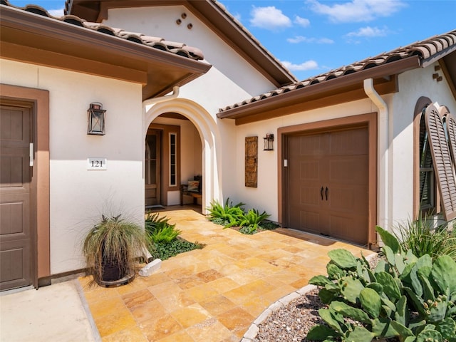 121 Wild Honeysuckle Way, San Marcos, TX 78666 - view of exterior entry featuring stucco siding, a tiled roof, and a garage