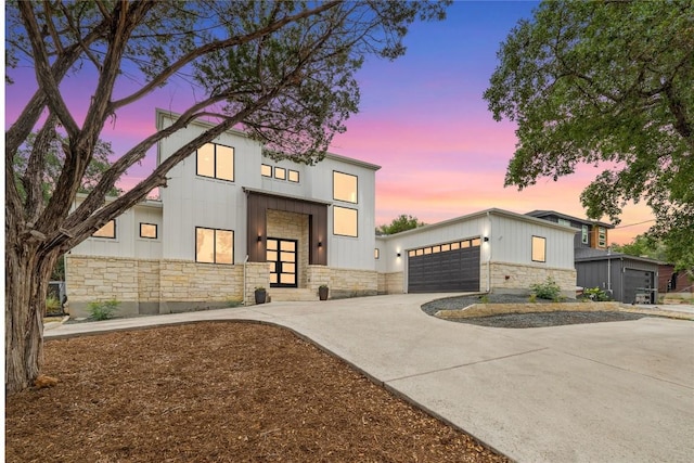 22005 Briarcliff Dr, Spicewood, TX 78669 - contemporary home with stone siding, concrete driveway, and board and batten siding