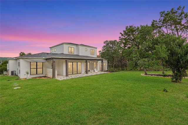 22005 Briarcliff Dr, Spicewood, TX 78669 - rear view of house featuring a lawn, cooling unit, a patio area, and a shingled roof