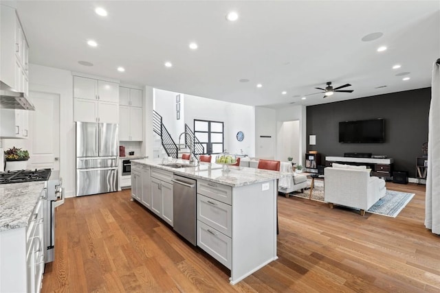 22005 Briarcliff Dr, Spicewood, TX 78669 - kitchen featuring stainless steel appliances, a sink, white cabinetry, ceiling fan, and light wood-style flooring