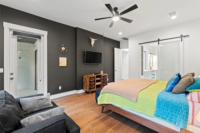 22005 Briarcliff Dr, Spicewood, TX 78669 - bedroom with a barn door, light wood-type flooring, baseboards, recessed lighting, and ceiling fan