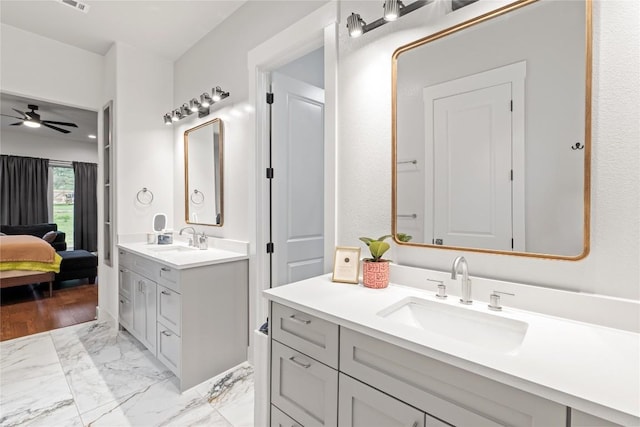 22005 Briarcliff Dr, Spicewood, TX 78669 - ensuite bathroom featuring ceiling fan, two vanities, and marble look tile flooring