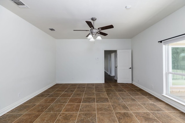 12011 Fm 1150th Rd, Luling, TX 78648 - spare room featuring ceiling fan, baseboards, and dark tile patterned flooring