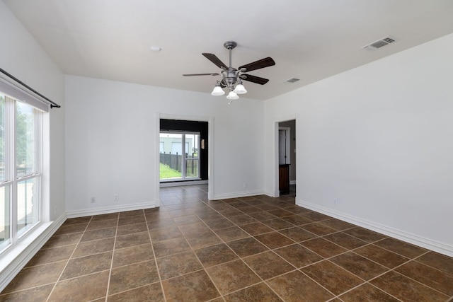 12011 Fm 1150th Rd, Luling, TX 78648 - empty room with ceiling fan, baseboards, and dark tile patterned flooring