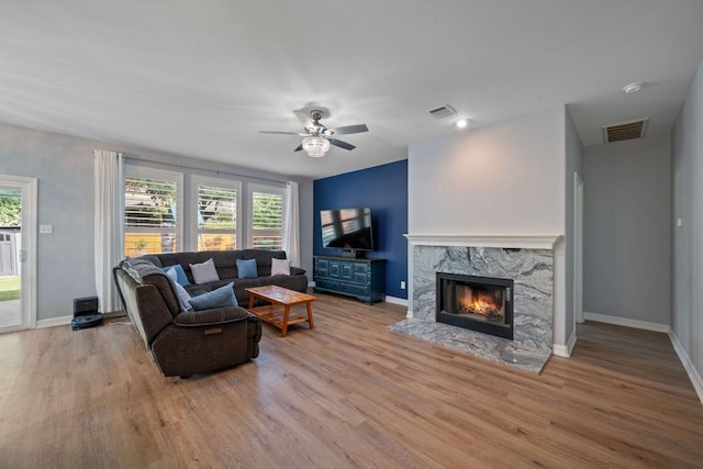 19402 Gale Meadow Dr, Pflugerville, TX 78660 - living area with wood finished floors, ceiling fan, baseboards, and a high end fireplace