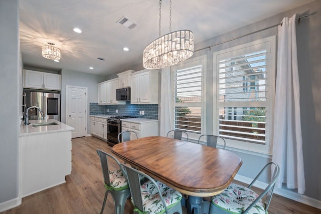 19402 Gale Meadow Dr, Pflugerville, TX 78660 - dining room with a chandelier, baseboards, light wood-style floors, and recessed lighting