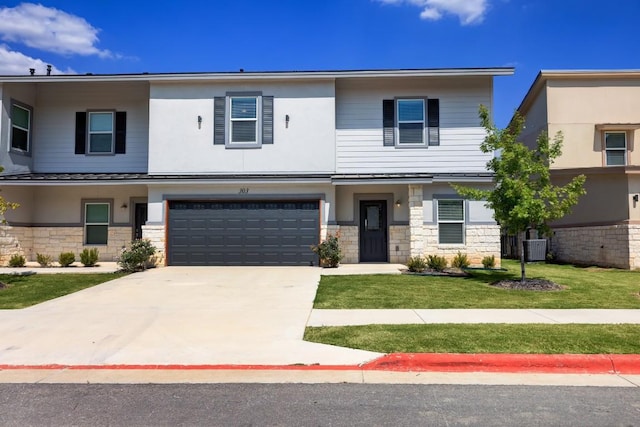 2105 Tiger Trl Unit 303, Round Rock, TX 78665 - view of front facade with an attached garage, concrete driveway, central air condition unit, a front yard, and stone siding