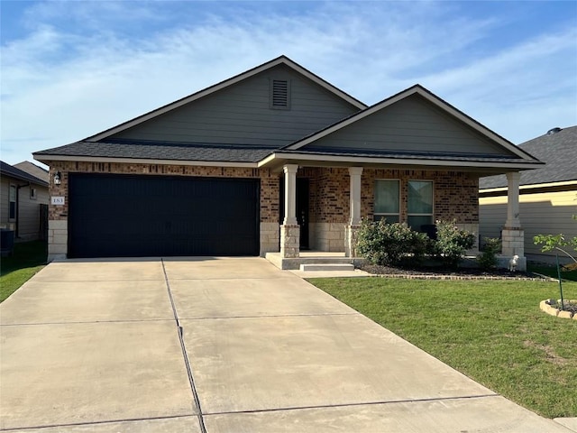 183 Beth Ann Loop, Taylor, TX 76574 - view of front facade featuring a front yard, brick siding, a porch, a garage, and concrete driveway