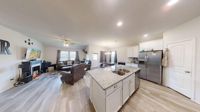 183 Beth Ann Loop, Taylor, TX 76574 - kitchen with stainless steel appliances, light wood-style floors, white cabinets, ceiling fan, and an island with sink