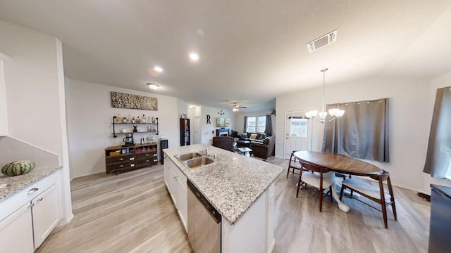 183 Beth Ann Loop, Taylor, TX 76574 - kitchen with stainless steel dishwasher, light wood finished floors, white cabinetry, and a kitchen island with sink