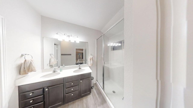 183 Beth Ann Loop, Taylor, TX 76574 - bathroom featuring double vanity, wood finished floors, and a stall shower