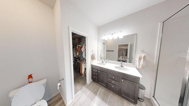 183 Beth Ann Loop, Taylor, TX 76574 - bathroom with wood finished floors, double vanity, a walk in closet, and an enclosed shower
