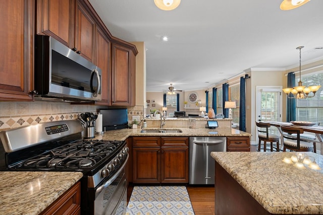 1504 Edelweiss Dr, Cedar Park, TX 78613 - kitchen featuring stainless steel appliances, a sink, open floor plan, a peninsula, and tasteful backsplash