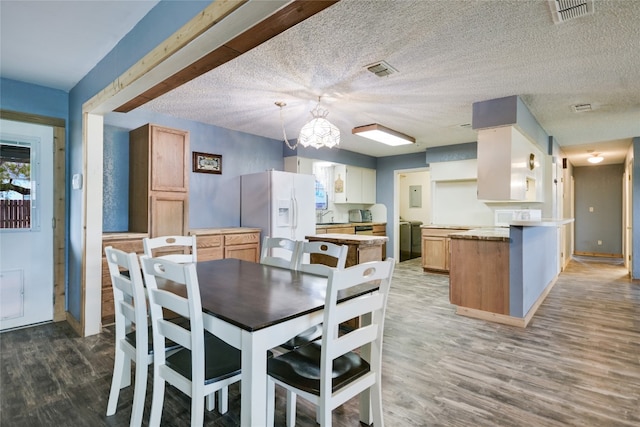 838 Pine Ln, Cottonwood Shores, TX 78657 - dining space featuring wood finished floors, a textured ceiling, baseboards, and plenty of natural light