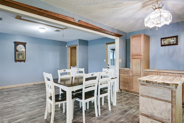 838 Pine Ln, Cottonwood Shores, TX 78657 - dining space with wood finished floors, a textured ceiling, and baseboards
