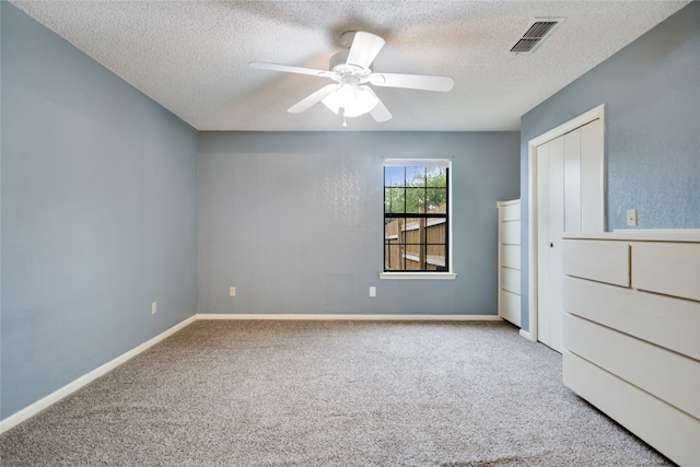 838 Pine Ln, Cottonwood Shores, TX 78657 - unfurnished bedroom featuring carpet floors, a textured ceiling, a closet, baseboards, and ceiling fan