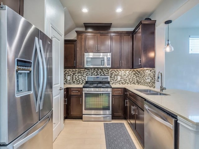 124 Cumberland Rd Unit 401, Austin, TX 78704 - kitchen featuring stainless steel appliances, a sink, dark brown cabinets, a peninsula, and decorative backsplash