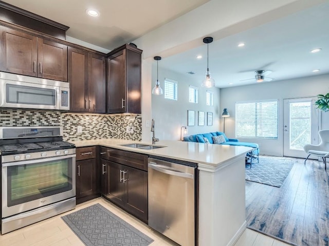 124 Cumberland Rd Unit 401, Austin, TX 78704 - kitchen featuring appliances with stainless steel finishes, a sink, open floor plan, dark brown cabinets, and ceiling fan