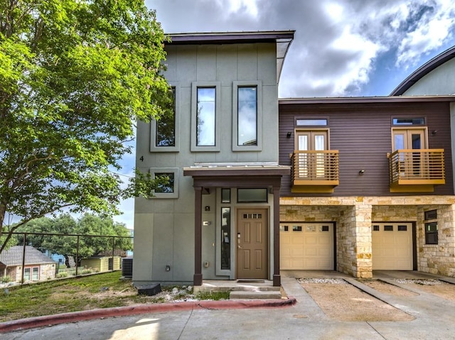 124 Cumberland Rd Unit 401, Austin, TX 78704 - view of front of property featuring a balcony, an attached garage, driveway, central AC, and stone siding