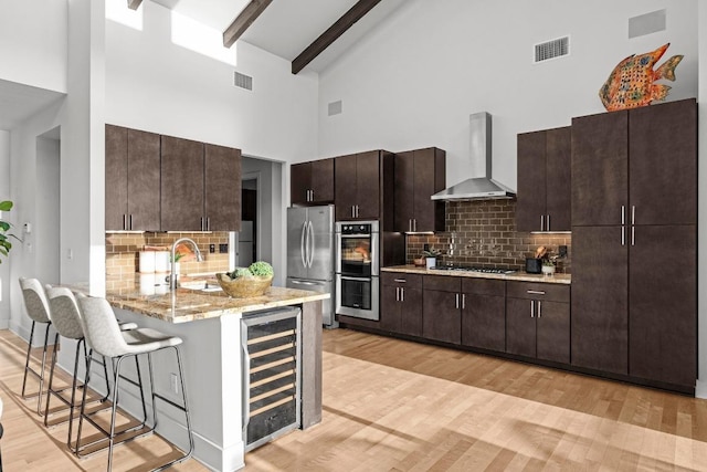 19000 Silver Maple Dr, Lago Vista, TX 78645 - kitchen featuring wall chimney range hood, beverage cooler, high vaulted ceiling, appliances with stainless steel finishes, and a sink