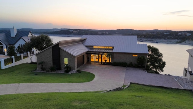 19000 Silver Maple Dr, Lago Vista, TX 78645 - contemporary home with a standing seam roof, brick siding, a garage, driveway, and metal roof