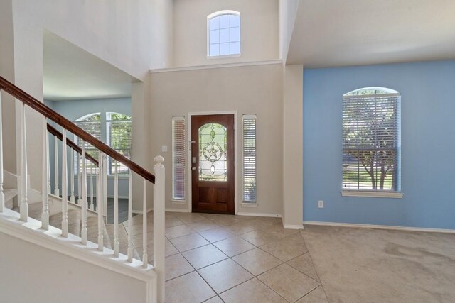 13617 Sun Dapple Ct, Manor, TX 78653 - tiled foyer entrance with healthy amount of natural light, stairs, baseboards, a towering ceiling, and carpet flooring
